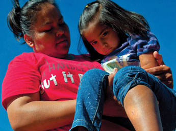 Danika Ruth Joe, 4, is held by her mother Melissa at their home near PIne Springs on Saturday. Joe was bitten by a Mojave Green Rattlesnake last week and has survived thanks to the quick work by EMS workers. The Mojave Green venom attacks the central nervous system and because of Joe's age, she is lucky to be alive. &copy; 2011 Gallup Independent / Adron Gardner 